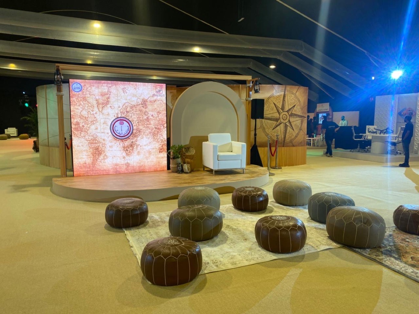 SINF 2025 built stage with Ibn Battuta map backdrop and Moroccan leather poufs